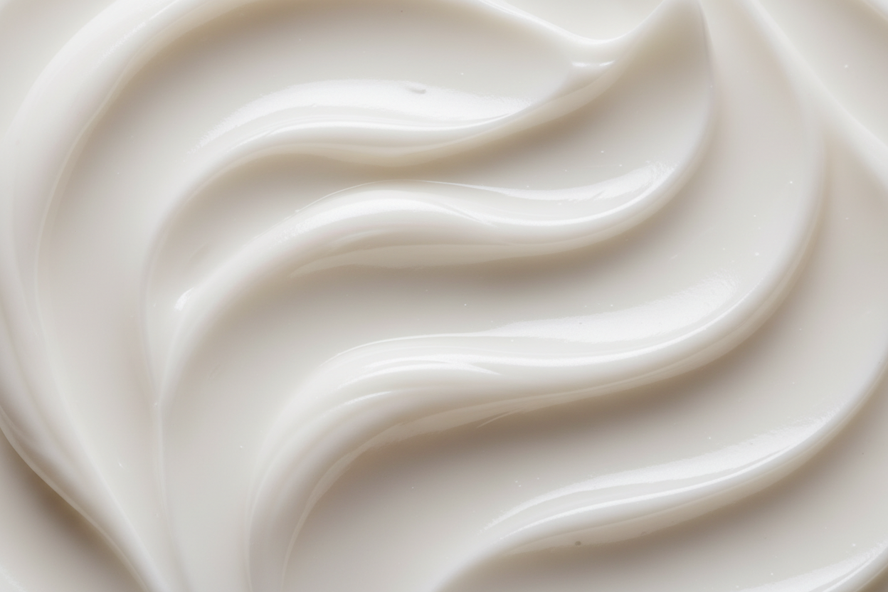 Macro shot of rich cream or lotion texture with smooth swirls and pearly highlights, symbolizing barrier repair. Clean minimal background, soft neutral lighting, luxurious skincare product photography. Make it look clean
